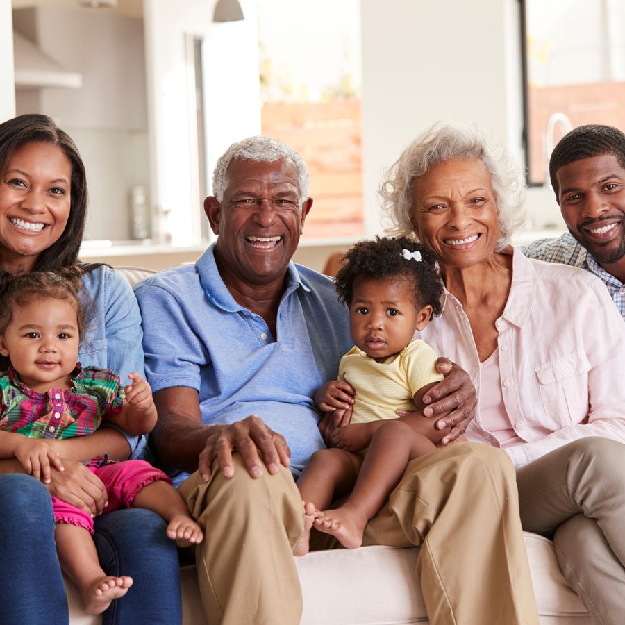 Three generations of a family sitting together on a sofa